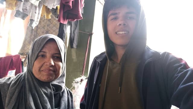 Mahmoud Elhelu, 21, and his mother in a makeshift tent at Rafah Camp, located in the southern part of the Gaza Strip