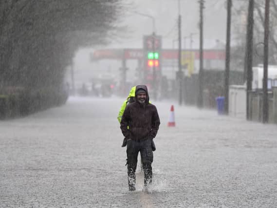 A person walking through floodwater on a pavement