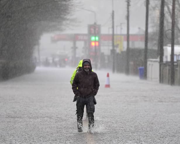 A person walking through floodwater on a pavement
